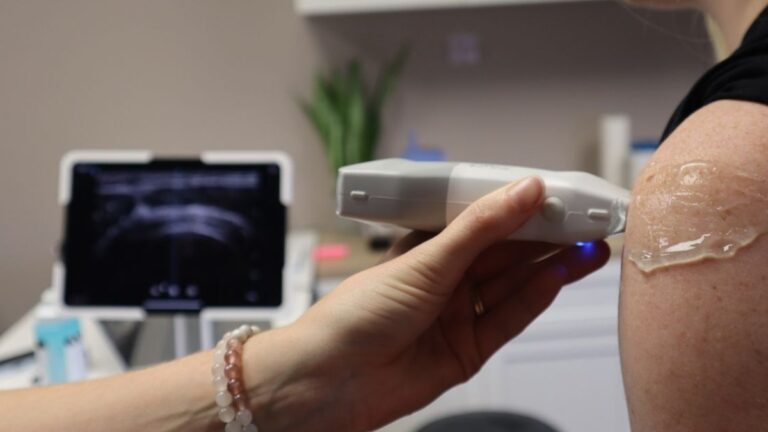 비수술 초음파 주사치료 글 대표이미지 · 사진: Doctor performing a shoulder ultrasound in a medical office with modern equipment.
