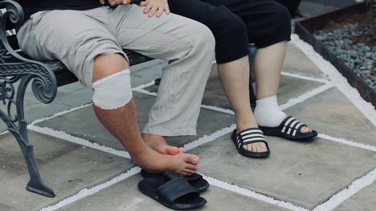 관리를 소홀히 하면 실제로 결과가 달라지나요? — 정확한 위치에 약물을 전달하는 것과, 그 이후 조직이 회복할 시간을 지켜주는 것은 서로 다른 문제입니다. 관절 주사 후 24시간… · 사진: Couple sitting on a bench with bandaged legs, outdoors in a patio settin…